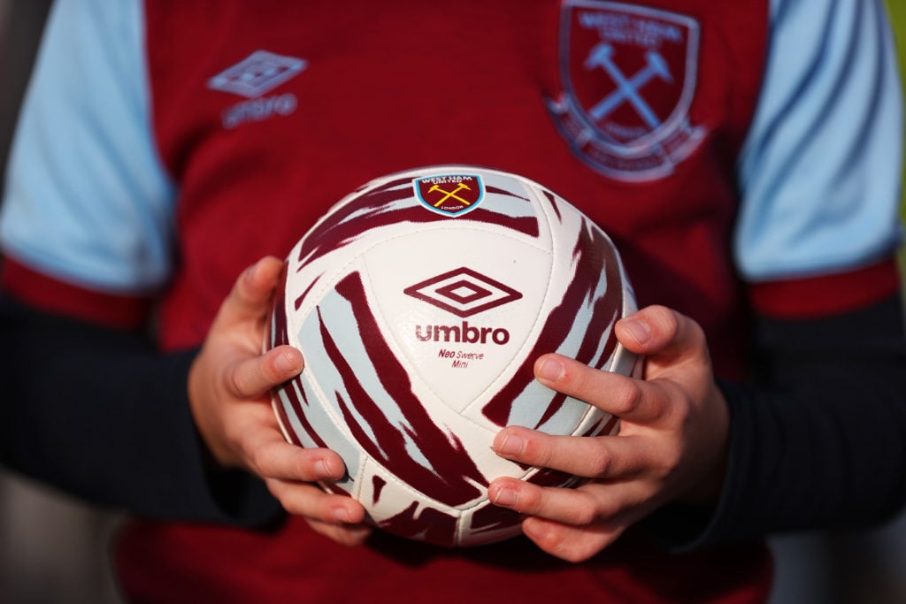 A fan of West Ham United is seen holding a West Ham United themed Umbro football prior to the Premier League match between West Ham United and Live...