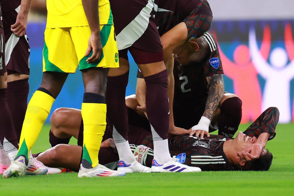 Edson Alvarez of Mexico reacts after being injured as his teammates watch on him during the CONMEBOL Copa America 2024 Group B match between Mexico...