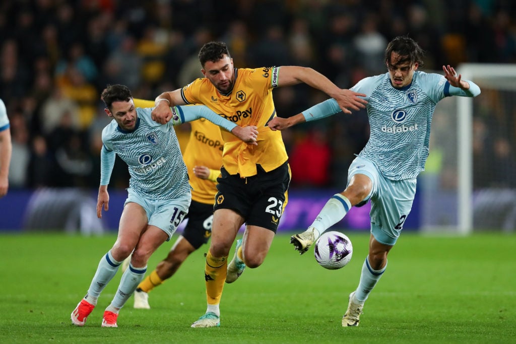 Adam Smith of Bournemouth (L), Max Kilman of Wolves, and Enes Unal of Bournemouth are in action during the Premier League match between Wolverhampt...