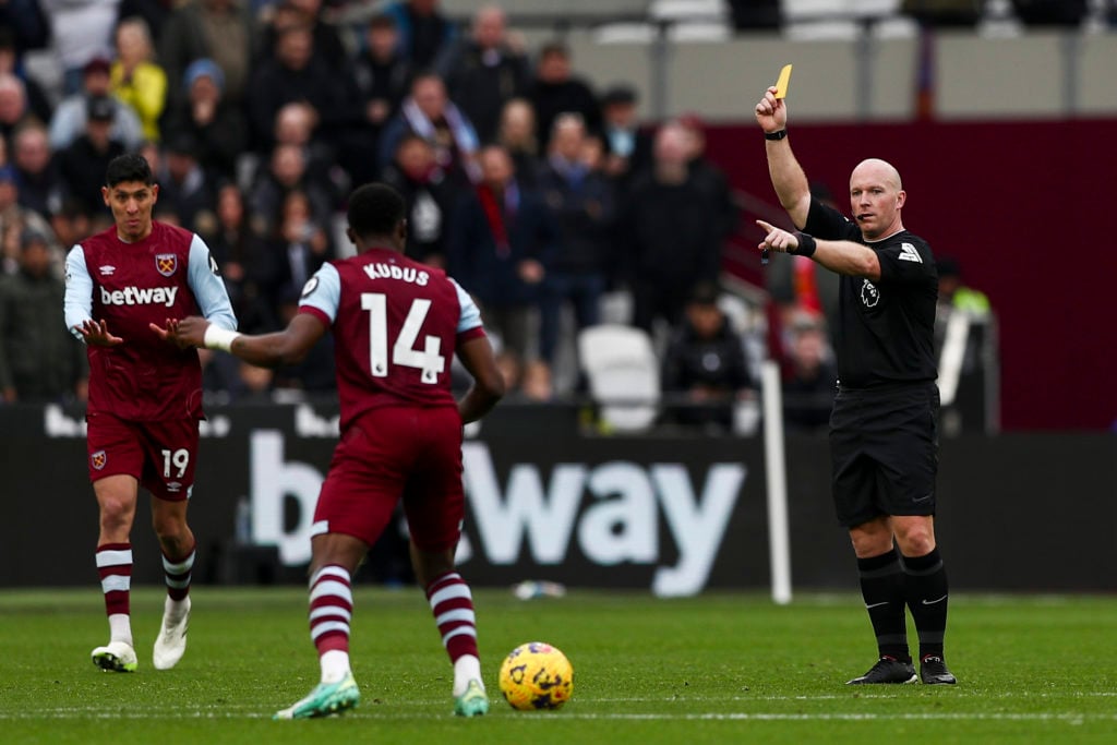 Match referee Simon Hooper is giving a yellow card during the Premier League match between West Ham United and Manchester United at the London Stad...