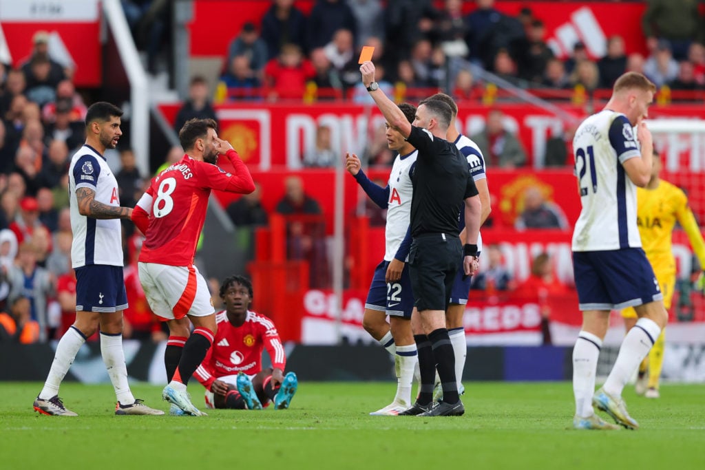 Bruno Fernandes of Manchester United is shown a red card by referee Chris Kavanagh during the Premier League match between Manchester United FC and...