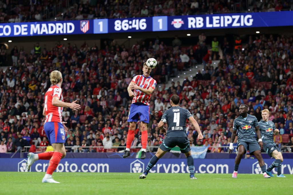 Alexander Sorloth of Atletico de Madrid wins the header before Willi Orban of RB Leipzig as Crypto.com LED boards are displayed during the UEFA Cha...