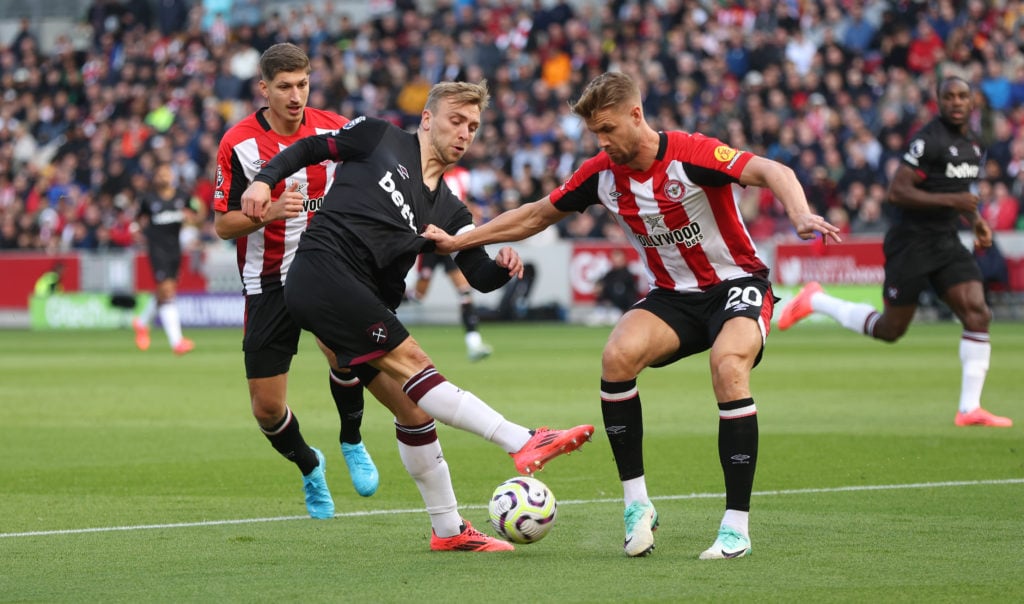 West Ham United's Jarrod Bowen crosses under pressure from Brentford's Kristoffer Ajer during the Premier League match between Brentford FC and Wes...