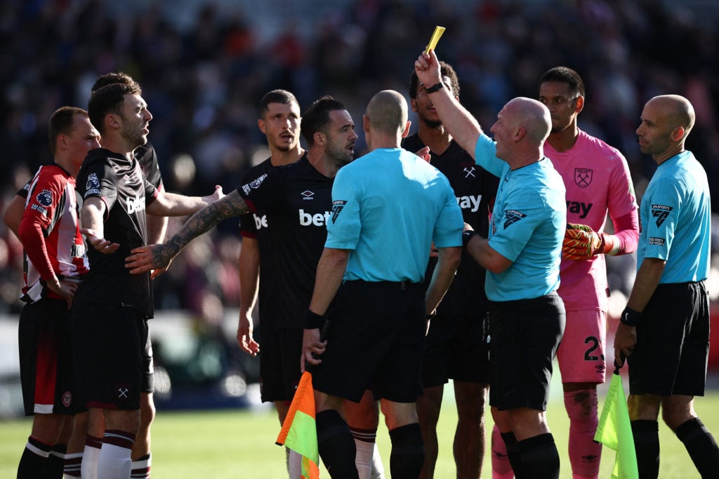 Referee Simon Hooper shows a yellow card to West Ham United's Scottish midfielder #39 Andy Irving during the English Premier League football match ...