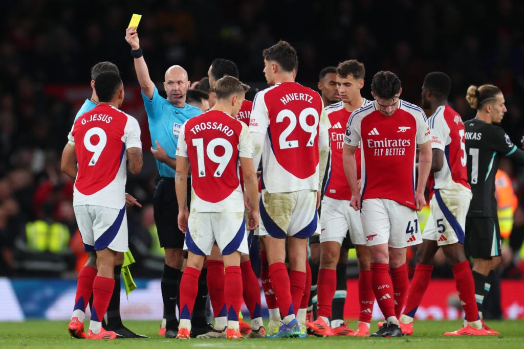 Gabriel Jesus of Arsenal is shown a red card as Arsenal players surround Referee Anthony Taylor at full-time during the Premier League match betwee...