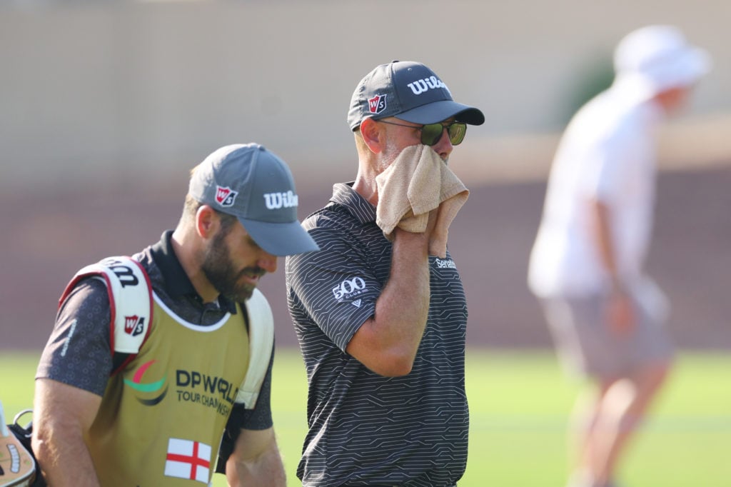 Paul Waring of England wipes his face as he walks on the 12th hole on day one of the DP World Tour Championship 2024 on the Earth Course at Jumeira...