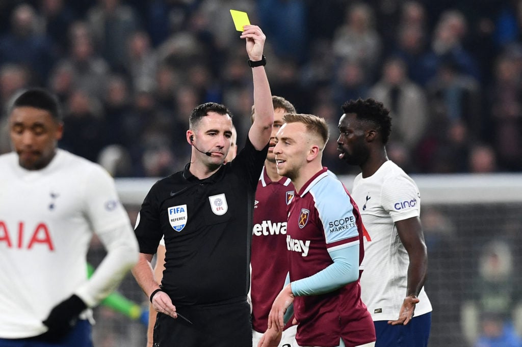 English referee Chris Kavanagh shows a yellow card to West Ham United's English striker Jarrod Bowen (2nd R) during the English League Cup quarter-...