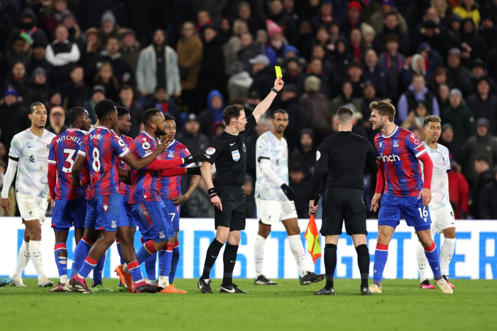 Joachim Andersen of Crystal Palace receives a yellow card from Referee Darren England during the Premier League match between Crystal Palace and Li...