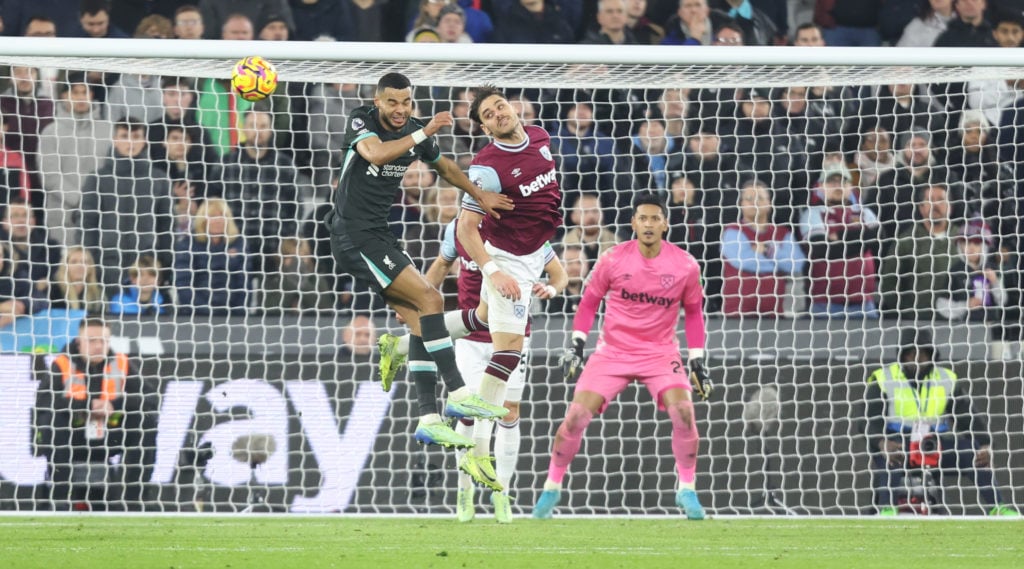 West Ham United's Konstantinos Mavropanos heads clear from Liverpool's Cody Gakpo during the Premier League match between West Ham United FC and Li...