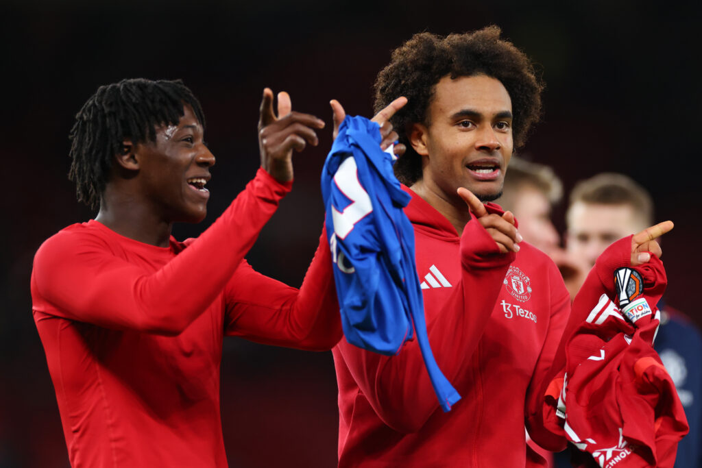 Man United teammates Kobbie Mainoo and Joshua Zirkzee chat as they applaud the fans