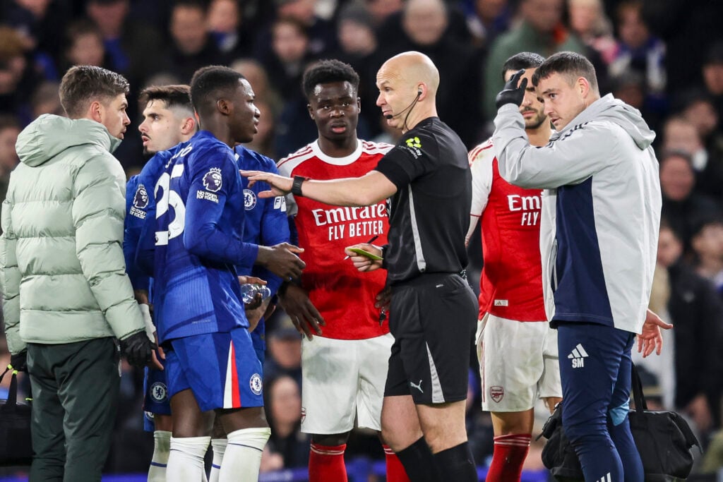 Moisés Caicedo of Chelsea with Referee Anthony Taylor before he is shown a straight red card during the Premier League match between Chelsea and Arsenal