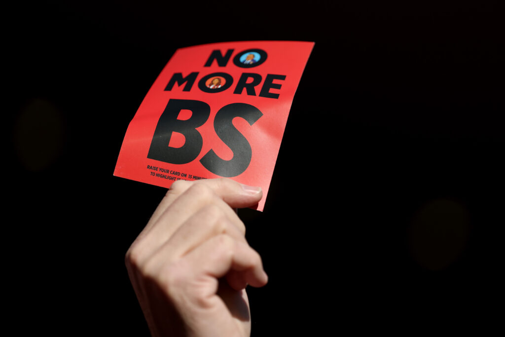 West Ham fans hold up leaflets reading 'No more bs' during the Premier League match against Liverpool at Anfield