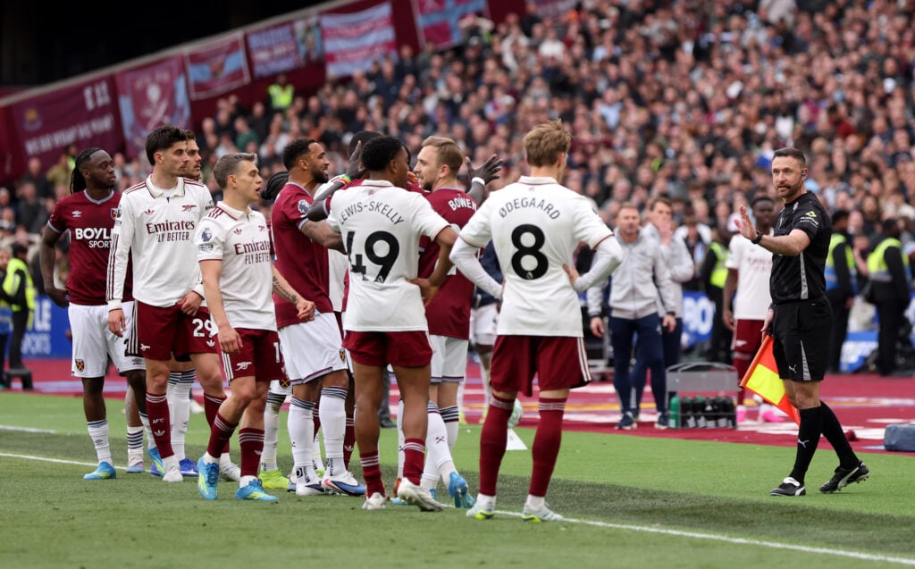 Assistant Referee, Dan Cook gestures towards players as they react to the VAR review concerning a foul on David Raya of Arsenal (not pictured) by Pablo of West Ham United.